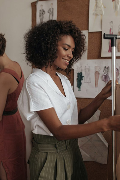 curly-attractive-dark-skinned-woman-in-white-blouse-and-khaki-shorts-works-as-fashion-designer-sho-1536×1024